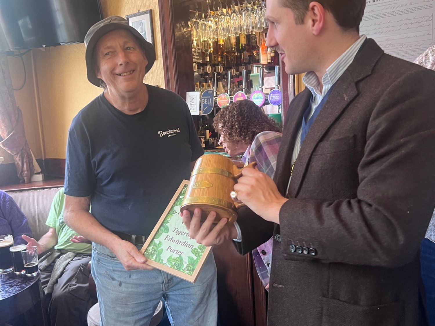 Liam Randall presents the Best Beer from the Wood trophy, a small oak tankard bound in brass, to the winner from Tigertops Brewery in the bar of the Swan in York.